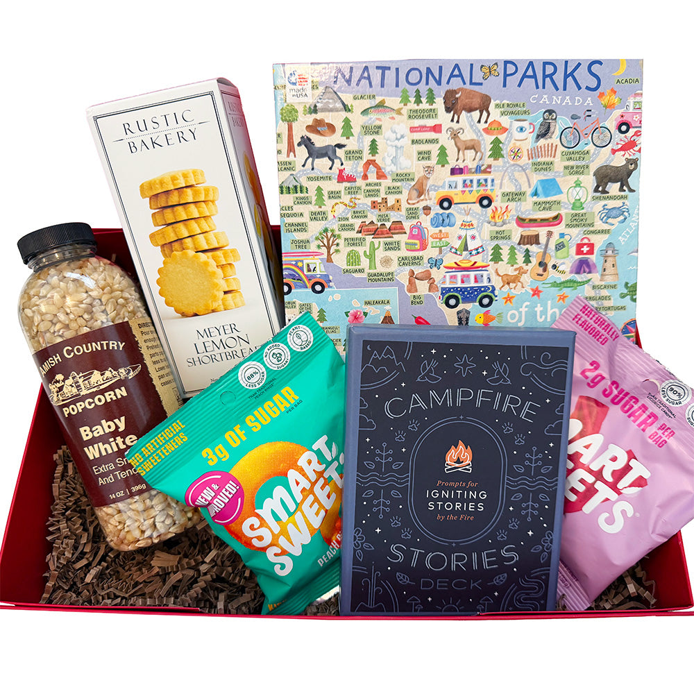 Assorted items including snacks, a map, and a book in a box with a red interior.