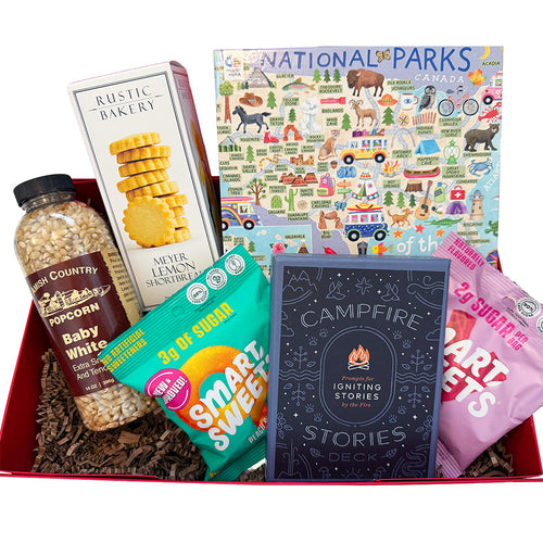 Assorted items including snacks, a map, and a book in a box with a red interior.