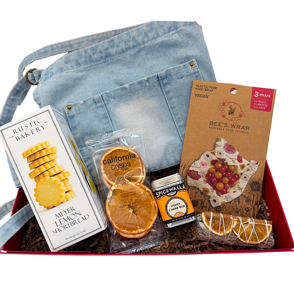 Assorted food items and a denim apron in a box